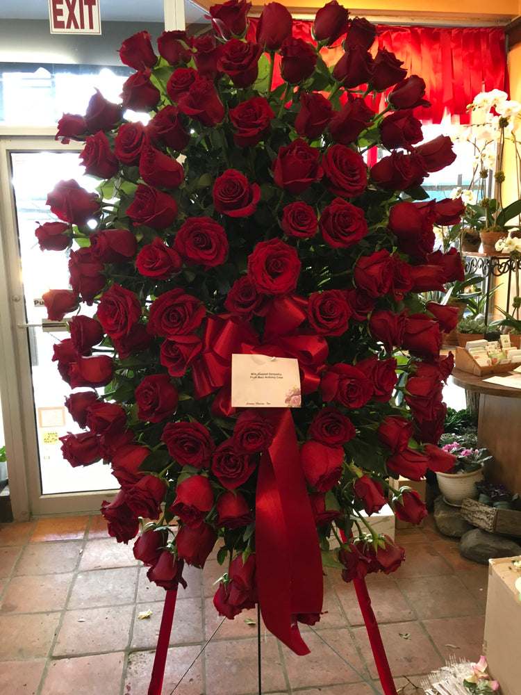 Tranquil roses sympathy spray with red roses on easel