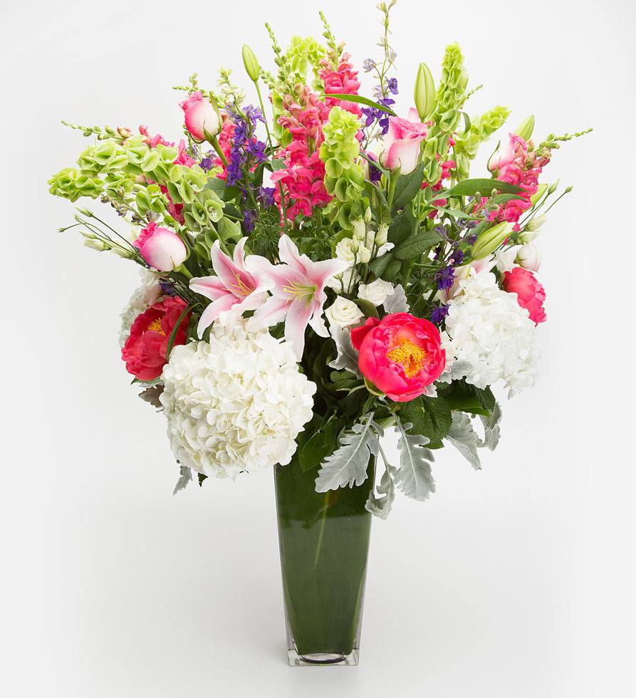 Springtime Flower arrangement with hybrid lilies, bells, roses, hydrangeas, and snapdragons.