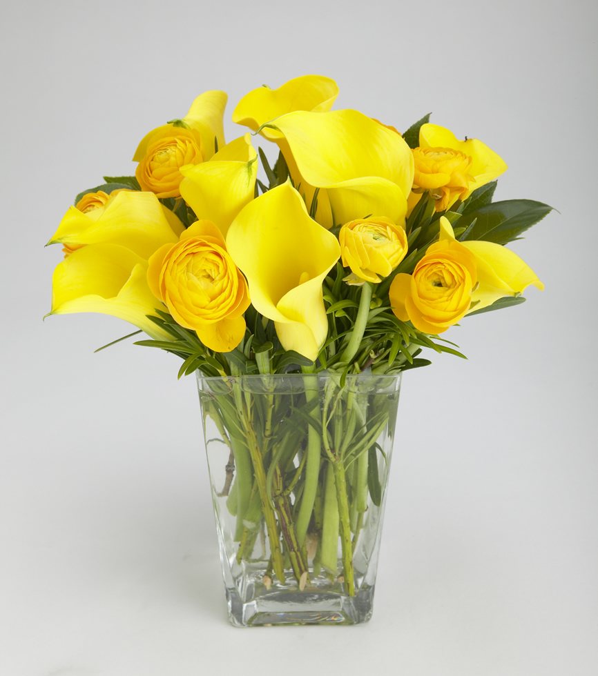 Cluster of ranunculus flowers and yellow calla lilies