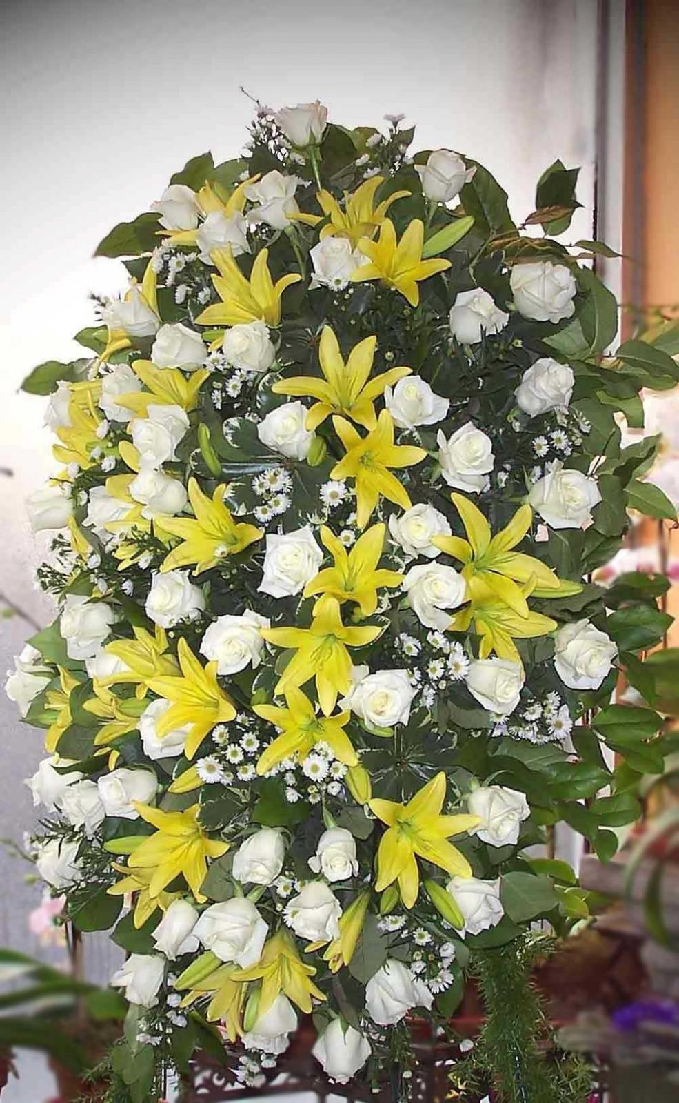Large sympathy spray with white roses and yellow lilies on an easel