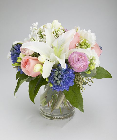 Lullaby flower arrangement with lilies, pink roses, hyacinths, and lisianthus in a cylinder vase